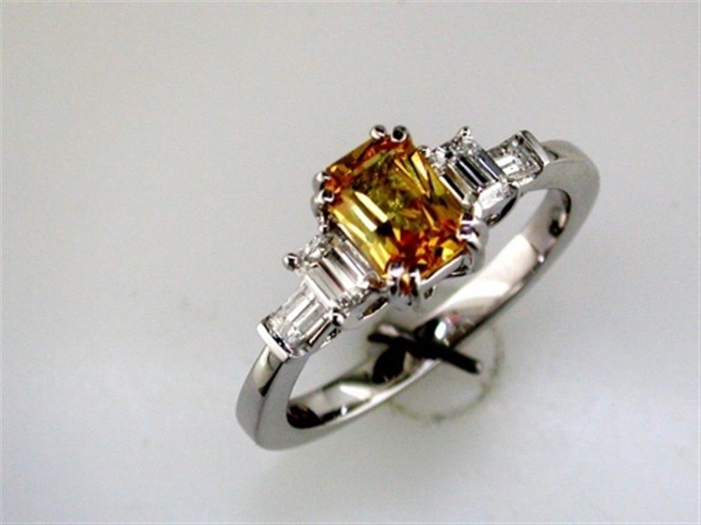 The Royal Jewelry 14K White Gold Yellow Sapphire and Diamond Ring, Size 6.75, features a stunning yellow sapphire center encircled by smaller diamonds, with rectangular diamonds extending along the band.