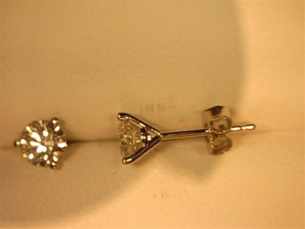 A close-up image of a single 14KW 3/4 CTTW Lab Grown Diamond Stud by Simply Diamonds, featuring a sparkling round-cut lab-grown diamond set in a pristine gold prong setting, placed against a light background.