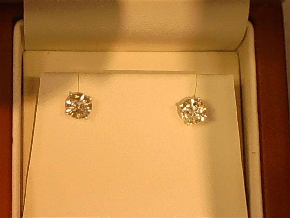 A pair of Veer 14KW 4-prong / 1.5ctw screw back stud earrings are showcased in a jewelry box. The round-cut diamonds, set in 14KW, rest on a cream-colored cushion with the box interior softly illuminated.