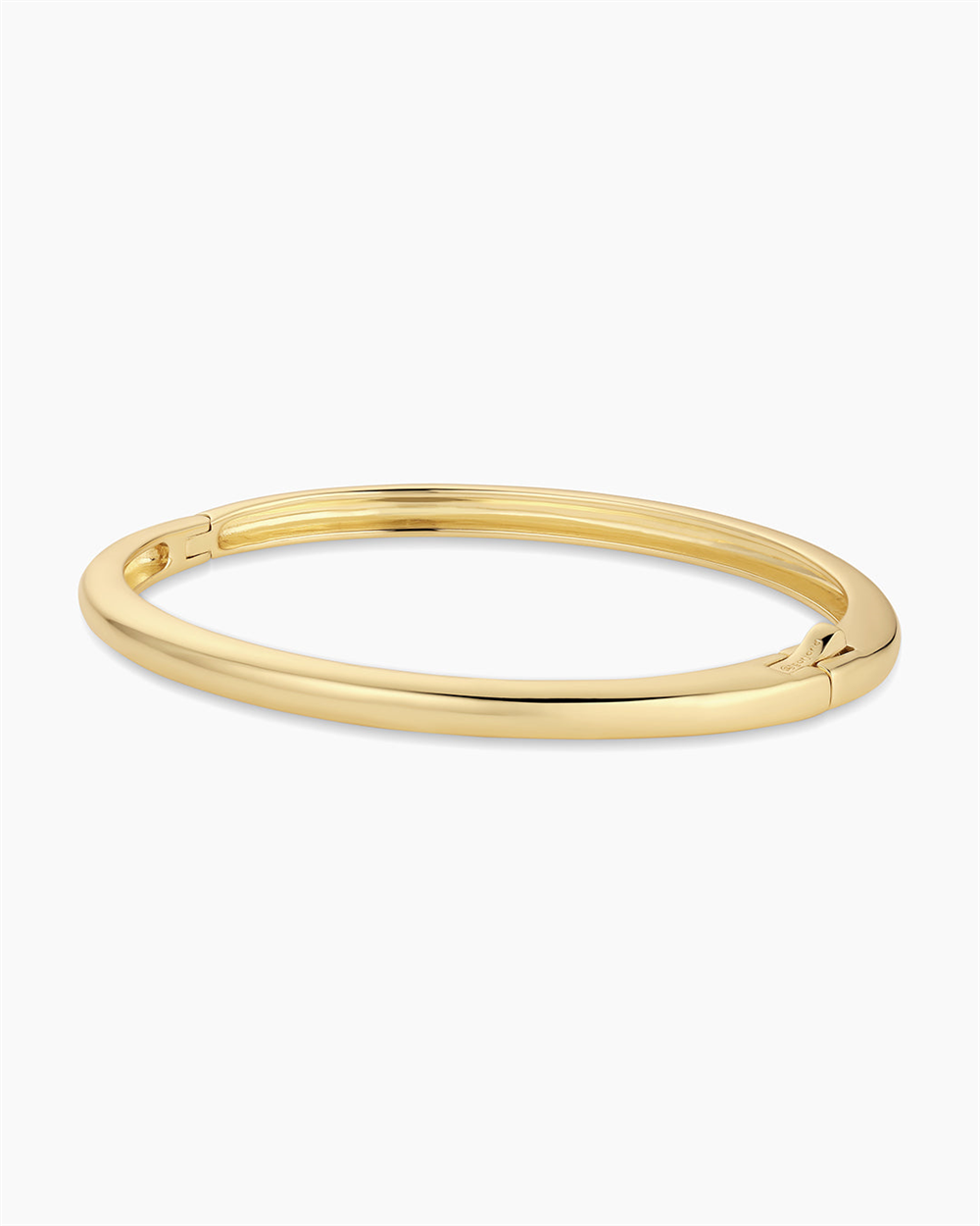 The Gorjana Paseo Cuff is an 18k gold plated bangle bracelet featuring a smooth, oval shape and discreet hinge clasp, shown against a plain white background.