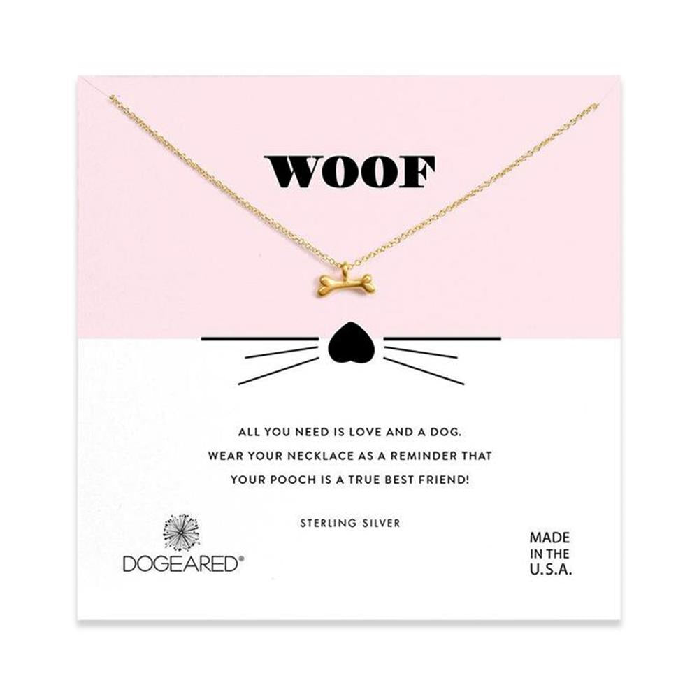 An image of a card showcases a gold dog bone necklace. The card prominently displays "WOOF" in GP-SS letters above the necklace, accompanied by a small heart and whiskers illustration. Additional text reads: "All you need is love and a dog. Wear your necklace as a reminder that your pooch is a true best friend!" The card also features the brand name "Dogeared.