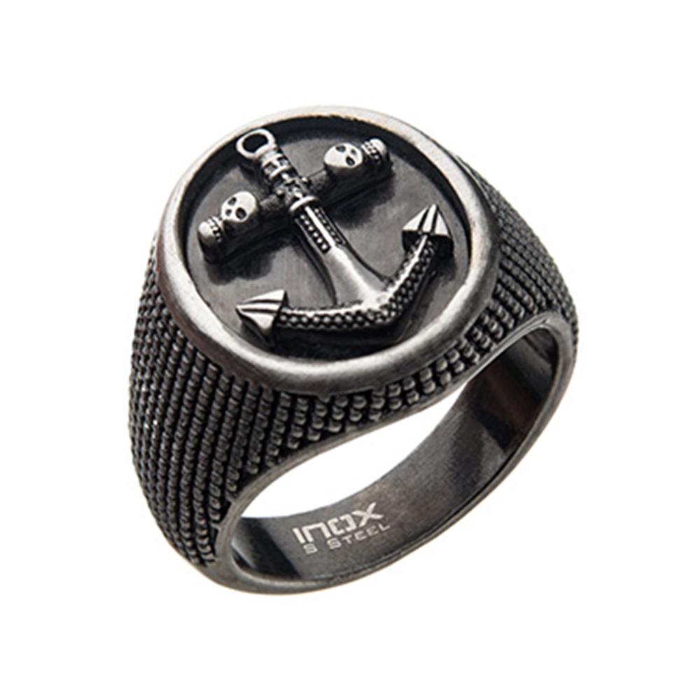 The INOX Men's Stainless Steel Antique Finished Signet Ring features a silver-toned, round face with an intricately engraved anchor and skull design. The anchor has a rustic, distressed finish, and the band is textured with a rugged pattern. The inside of the ring is stamped with "INOX" and "STEEL," adding to its vintage appeal.