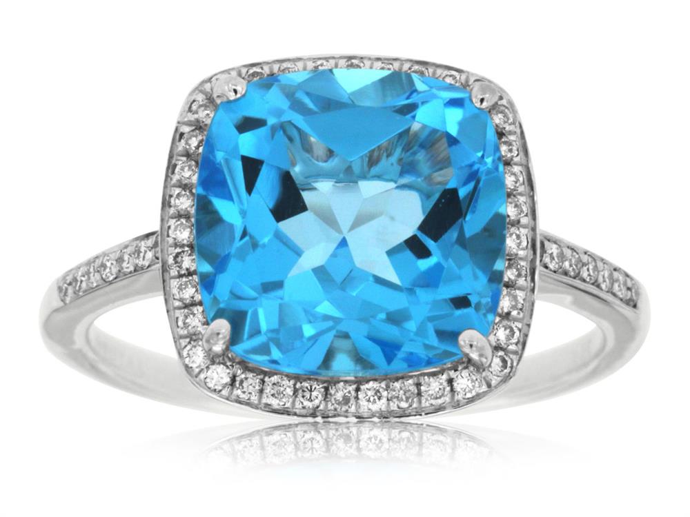The Royal Jewelry 14k WG Blue Topaz and Diamond ring features a large cushion-cut blue topaz surrounded by small diamonds. Its sleek band enhances the elegant design, making this exquisite size 7 ring truly stunning.