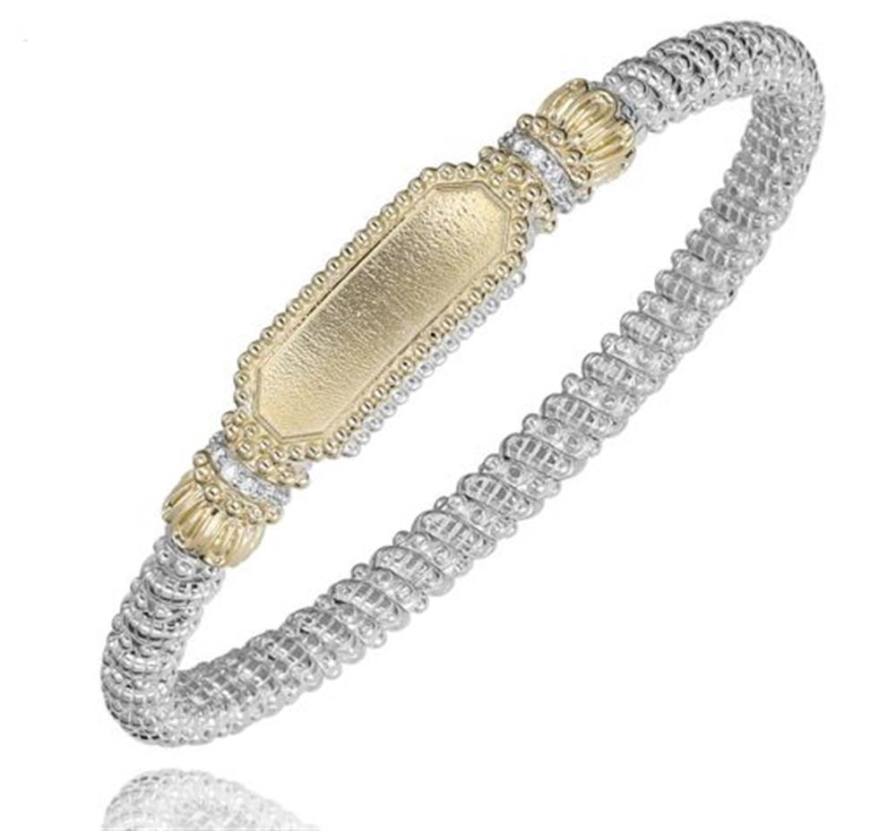 The Alwand Vahan Jewelry 4MM Closed Band 0.08ct / Size B1 / 23473D04 is a decorative bangle bracelet that features a textured gold central plate with ornate ends, flanked by ridged silver segments. Its detailed, intricately woven design seamlessly combines both gold and silver elements to create a sophisticated and elegant appearance.