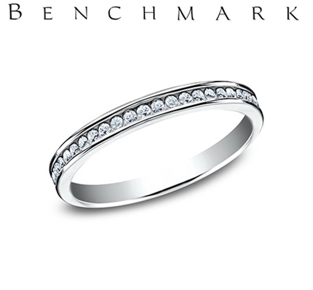 A sleek, silver 14K white gold channel set band ring featuring a continuous row of small lab-grown diamonds totaling 0.23 carats. "Benchmark Rings" is elegantly displayed in capital letters above the ring.