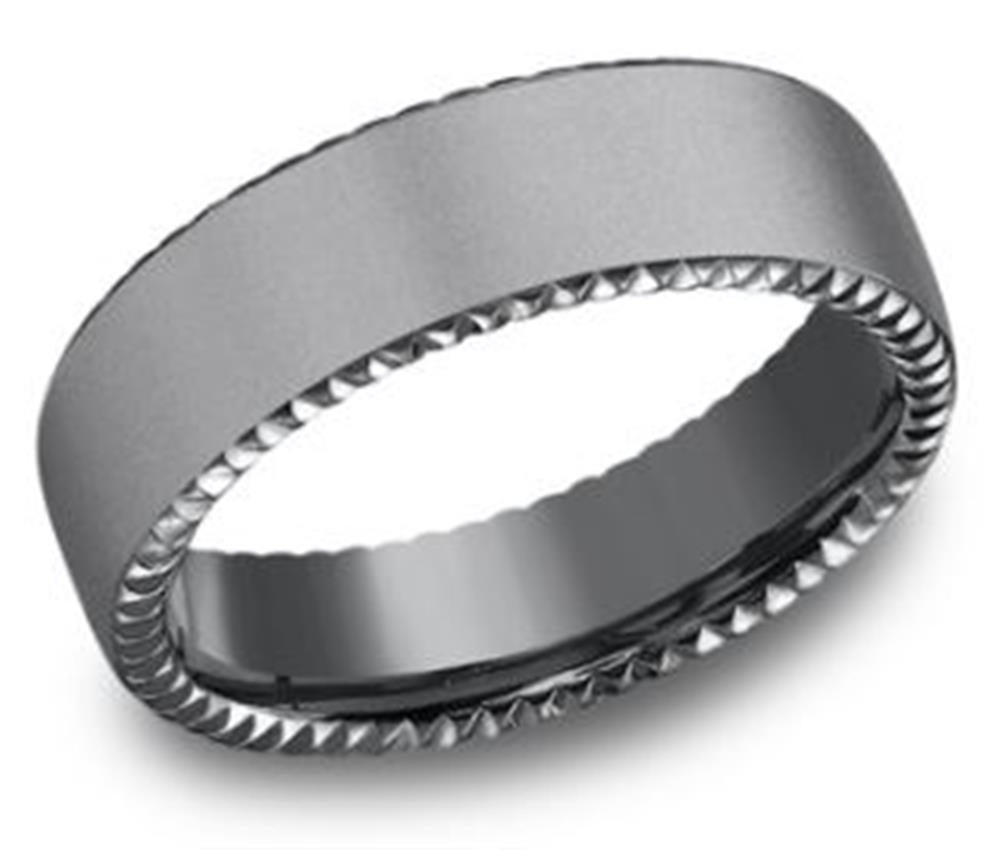 The 6.5mm Rivet Coin Edge and Sandblast Ring from Benchmark Rings features a smooth matte finish on the outer surface and a detailed, jagged pattern reminiscent of a Rivet Coin Edge on the inner edge. Its modern design gives it a sleek, contemporary appearance.