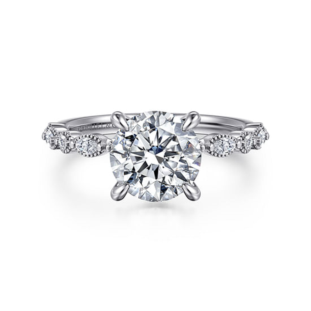 The Gabriel & Co 14K White Gold Round Diamond Engagement Ring, head size 7.4 and ring size 6.5, features a large round center diamond with smaller round and marquise diamonds along the band, shown on a white background.