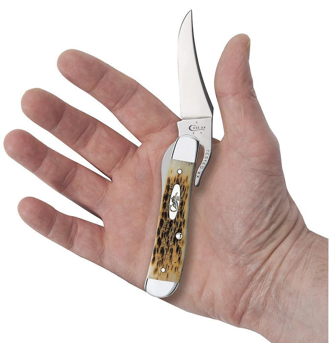 A hand holding a RussLock® Knife from W.R. Case & Sons Cutlery Co., showcasing a polished Tru-Sharp™ stainless steel blade and an Amber Bone design with a speckled pattern on the handle, complete with a silver bolster and shield emblem.