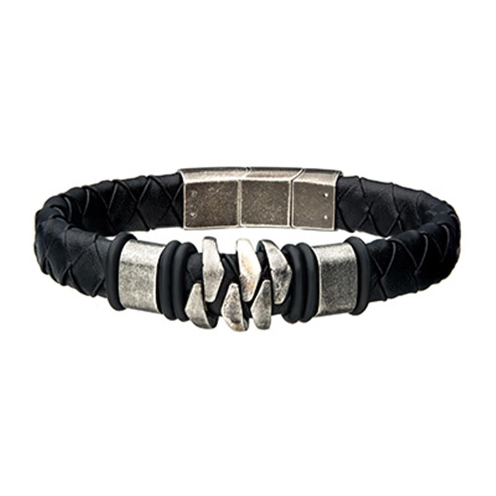The Men's Stainless Steel and Gun Metal Black Leather Bohemian Bracelet from INOX features a black braided leather band with a metallic clasp. The centerpiece boasts three interlocking silver segments flanked by black rubber rings, exuding a rugged and masculine design.