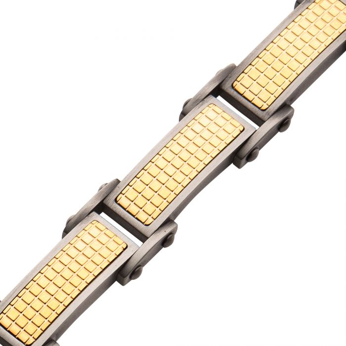 A close-up of the Gun Metal Plated Bracelet with 18K Gold by INOX. The bracelet features a gold-tone textured surface in rectangular sections, bordered by silver-tone adjustable links. Its design combines an industrial yet elegant look with a modern, geometric pattern.