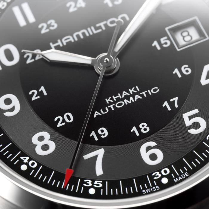 Close-up image of the Hamilton Khaki Field Automatic Watch | 42mm. The black dial showcases white Arabic numerals for both 12-hour and 24-hour formats, a date display at 3 o'clock, and a red-tipped second hand. The watch is powered by an impressive H-10 automatic caliber with an 80-hour power reserve.