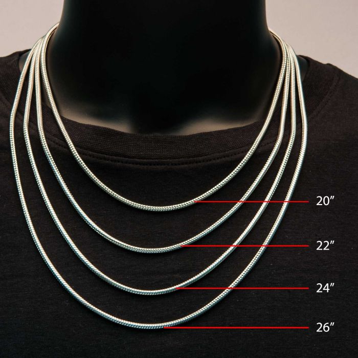 A black display mannequin adorned with five silver 3mm Steel Rattail Chains by INOX of varying lengths (20", 22", 24", and 26"), each labeled in red to indicate their respective lengths. The chains are laid out to showcase their differences in length, perfect for choosing the right men's necklace.