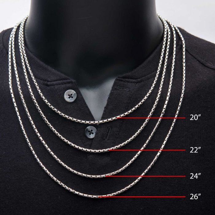 A mannequin dressed in a black shirt showcases four men's necklaces, crafted from stainless steel chains of varying lengths. The chains, labeled from top to bottom, measure 20 inches, 22 inches, 24 inches, and 26 inches. One of these is the INOX brand's 3mm Oxidized Steel Boston Link Chain at a length of 24 inches, effectively demonstrating the different lengths they reach on the chest.