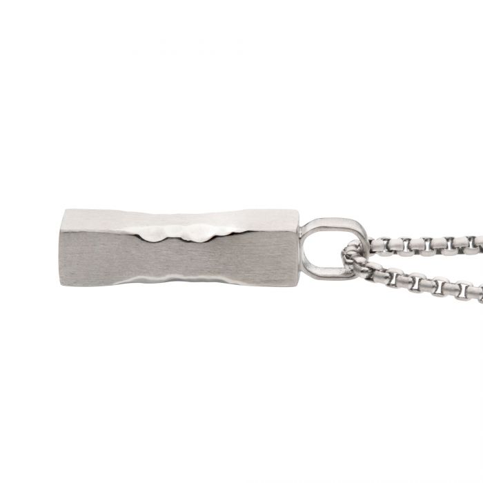 A matte steel chiseled drop pendant is attached to a delicate, engravable box chain from INOX. The chain features uniform, closely linked box-shaped links that create a contrasting texture with the smooth, polished surface of the men's pendant.