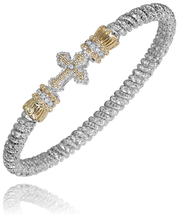 This Alwand Vahan Jewelry bracelet, crafted from sterling silver and 14k gold, boasts an intricate chain design. The centerpiece features a gold-toned cross adorned with small clear stones and bejeweled accents on either side. With a diamond weight of 0.08 carats and a band width of 4mm, this stunning piece sparkles elegantly.