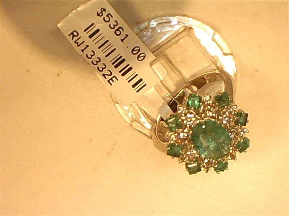 The Ryan Gems Diamond and Emerald cluster ring in 14k white gold, size 7, displays a central emerald surrounded by smaller green stones and diamonds. Priced at $5,361.00 with code RW13332E, it is shown on a white surface.