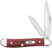 The Pocket Worn Corn Cob Jig Old Red Bone Peanut by W.R. Case & Sons Cutlery Co. is a red-handled pocket knife featuring two partially open stainless steel blades. The handle, meticulously crafted from Old Red Bone, is adorned with brass rivets and an oval metal emblem engraved with "Case XX." Its Corn Cob Jig texture offers a secure grip, complemented by polished metal caps at both ends.
