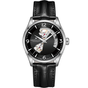 The Hamilton Jazzmaster Automatic Open Heart Watch features a sophisticated black leather strap. The timepiece has a sleek black dial with a partial skeleton design that showcases the intricate Swiss automatic movement inside. It is adorned with silver numerals and hour markers, encased in a polished silver casing, complete with a small crown on the right side.