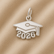 Celebrate the class of 2026 with the Rembrandt Charms Grad Cap 2026—Sterling Silver charm, featuring a mortarboard design with “2026” beneath, beautifully displayed on beige fabric—the perfect graduation gift.