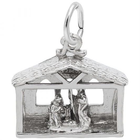 The Nativity Charm in sterling silver by Rembrandt Charms features a detailed depiction of Mary, Joseph, and baby Jesus in a stable with intricately designed windows and a textured roof. It is attached to a small hoop, making it perfect for wearing on a bracelet or necklace.