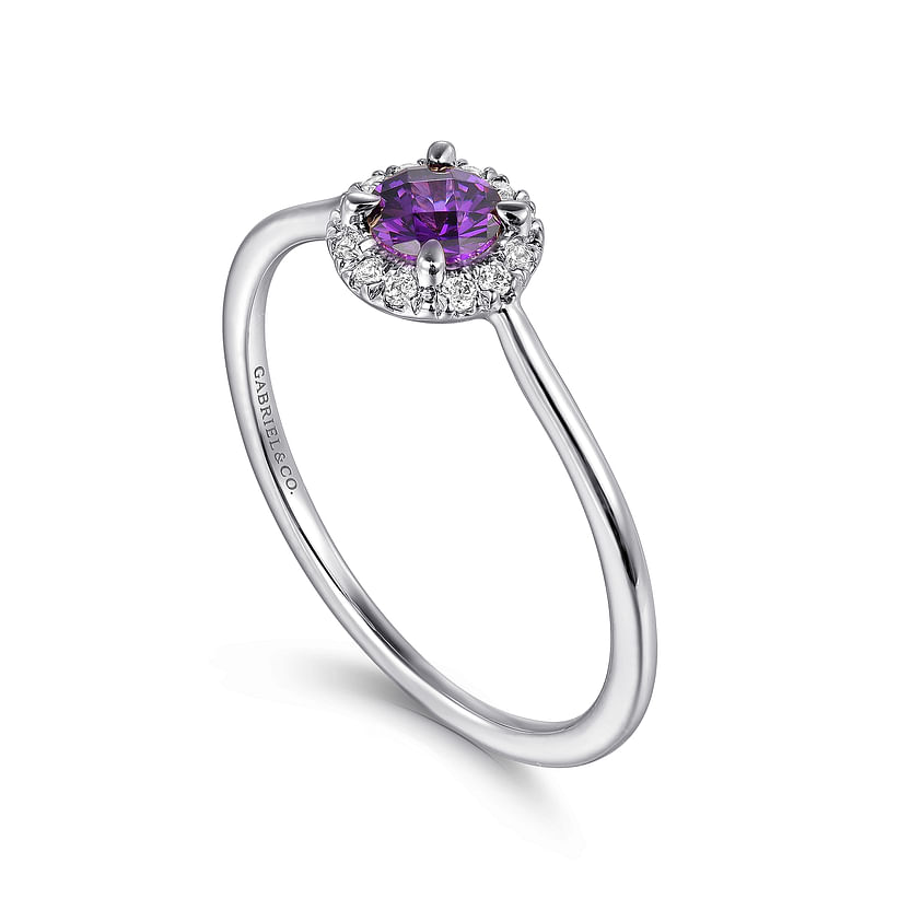 The Gabriel & Co 14K White Gold Amethyst and Diamond Halo Ring features a round purple amethyst center stone encircled by sparkling diamonds on a slim, polished band.