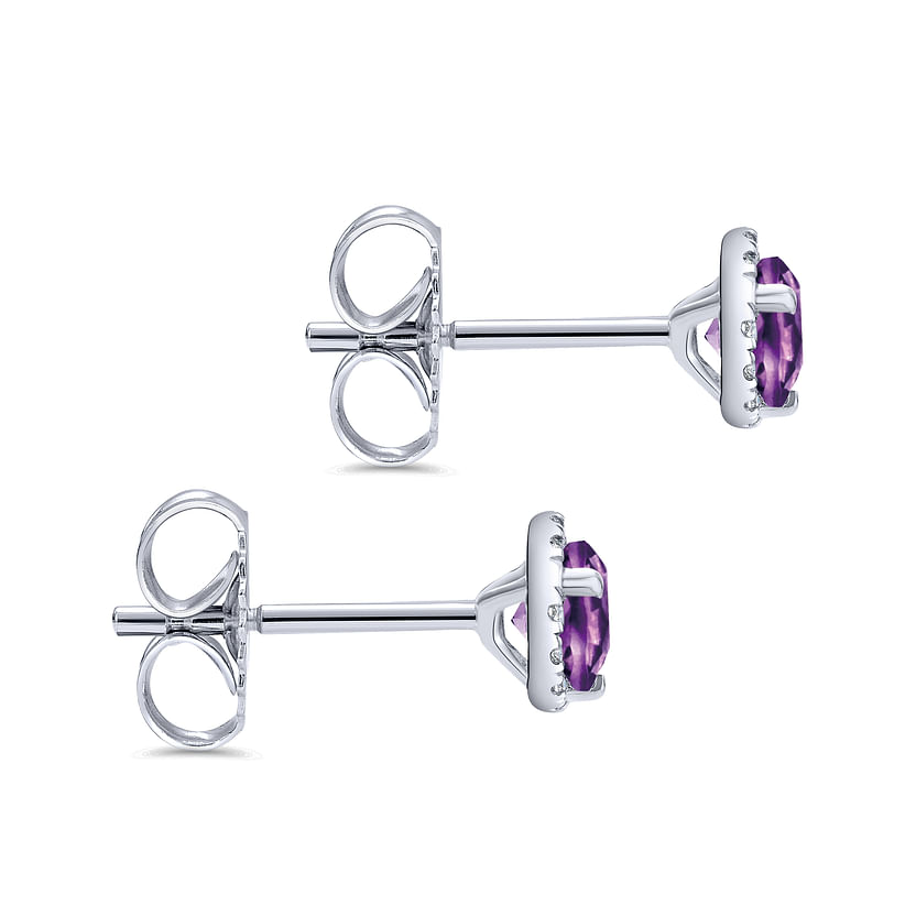 Gabriel & Co 14K White Gold Amethyst and Diamond Halo Stud Earrings, featuring round purple amethysts in four-prong settings with posts and butterfly backings, shown from the side.