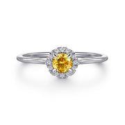 The Gabriel & Co 14K White Gold Citrine and Diamond Halo Promise Ring features a round yellow citrine center, encircled by sparkling diamonds, elegantly displayed on a white background.