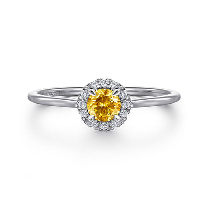 The Gabriel & Co 14K White Gold Citrine and Diamond Halo Promise Ring features a round yellow citrine center, encircled by sparkling diamonds, elegantly displayed on a white background.