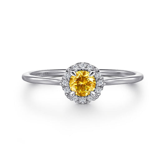The Gabriel & Co 14K White Gold Citrine and Diamond Halo Promise Ring features a round yellow citrine center, encircled by sparkling diamonds, elegantly displayed on a white background.
