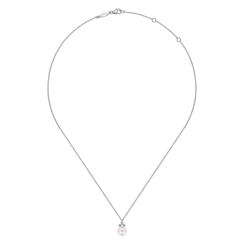 The Gabriel & Co 14K White Gold Diamond and Pearl Pendant Necklace features a round cultured pearl pendant accented by three sparkling diamonds, set on a delicate adjustable chain.