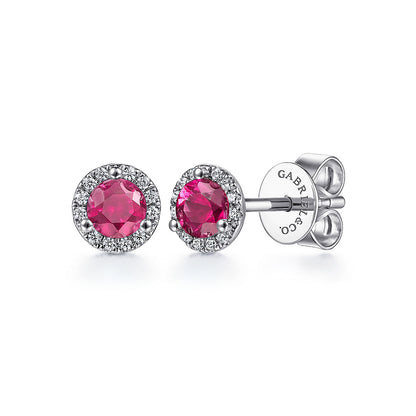 Gabriel & Co's 14K white gold stud earrings feature vibrant round rubies encircled by pavé-set natural diamonds with butterfly backs, engraved "GABRIEL & CO."—a stunning diamond and ruby combination.