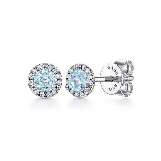 Gabriel & Co 14K White Gold Halo Aquamarine and Diamond Stud Earrings feature round light blue aquamarine centers encircled by small white diamonds with butterfly backs; the brand name is engraved on the back.