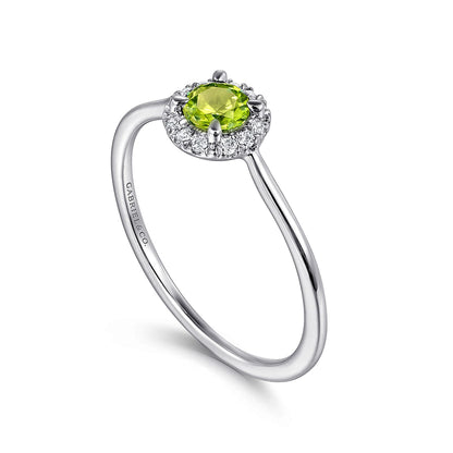 The Gabriel & Co 14K White Gold Peridot and Diamond Halo Promise Ring features a round green peridot center stone encircled by sparkling diamonds, shown against a white background.