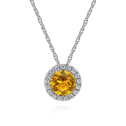The Gabriel & Co 14K White Gold Round Citrine and Diamond Halo Pendant Necklace features a vibrant citrine center surrounded by sparkling diamonds, creating an elegant statement piece.