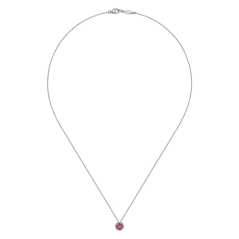 The Gabriel & Co 14K White Gold Ruby and Diamond Halo Pendant Necklace features a round ruby framed by sparkling diamonds, elegantly set in white gold and displayed against a white background.
