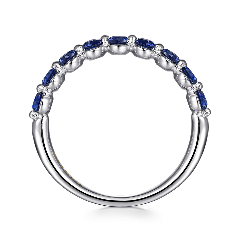 The 14K White Gold Sapphire Stackable Ring by Gabriel & Co showcases a row of oval blue sapphires set on the upper half of the silver-tone band, displayed against a white background.