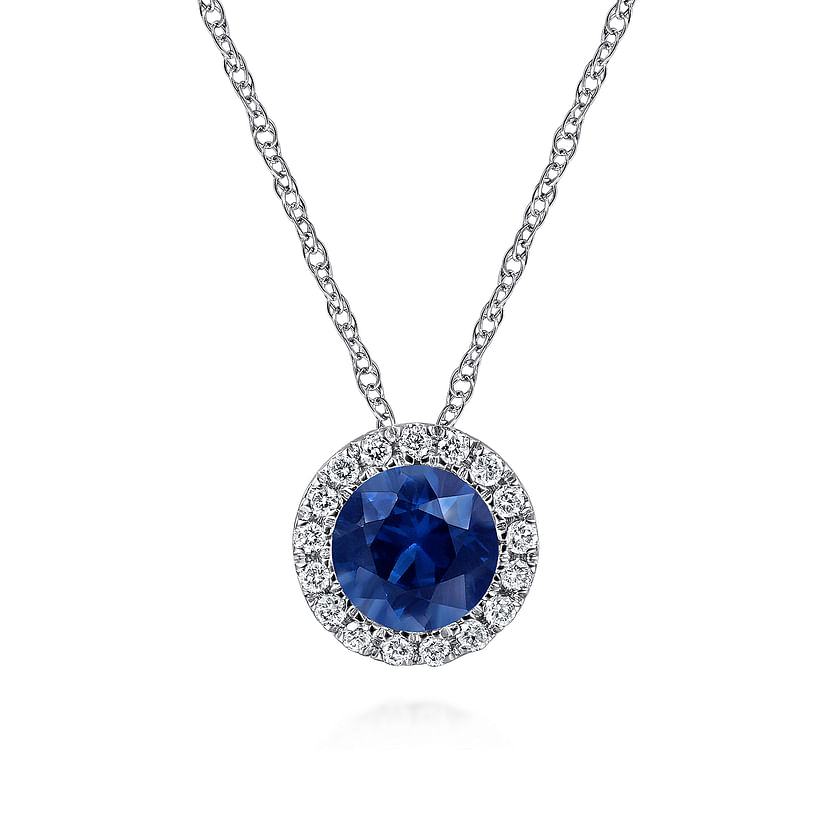 The Gabriel & Co 14K White Gold Sapphire and Diamond Halo Pendant Necklace features a round sapphire encircled by sparkling diamonds, elegantly displayed on a crisp white background.