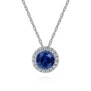 The Gabriel & Co 14K White Gold Sapphire and Diamond Halo Pendant Necklace features a round sapphire encircled by sparkling diamonds, elegantly displayed on a crisp white background.