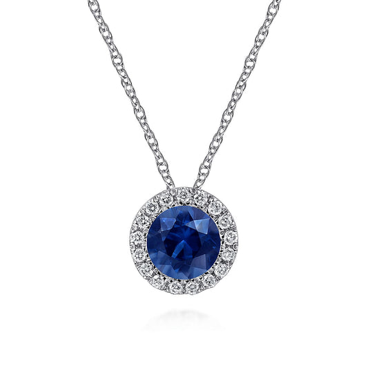 The Gabriel & Co 14K White Gold Sapphire and Diamond Halo Pendant Necklace features a round sapphire encircled by sparkling diamonds, elegantly displayed on a crisp white background.