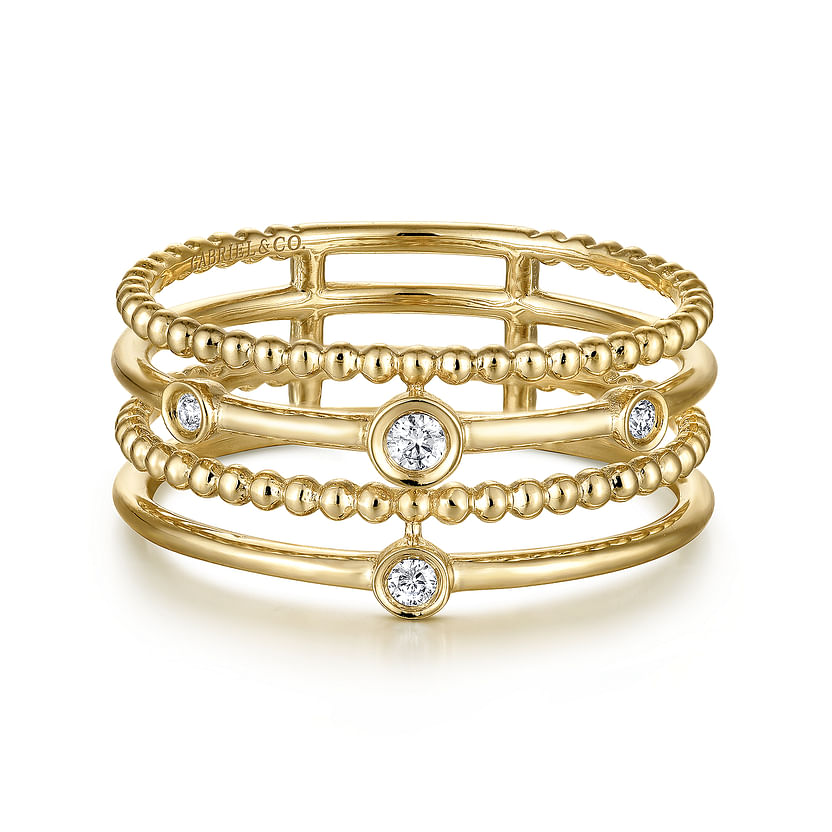 The Gabriel & Co 14K Yellow Gold Bezel Set Diamond Station Layered Ring features four parallel bands—two smooth, two with Bujukan beading—and five evenly spaced, round bezel-set diamonds.