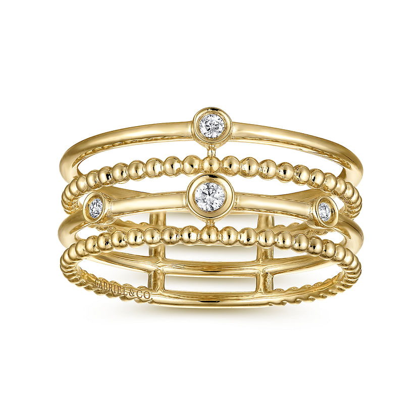 The Gabriel & Co 14K Yellow Gold Bezel Set Diamond Station Layered Ring features four stacked bands—two with Bujukan beading and two smooth—with five bezel-set diamonds spaced across the design.