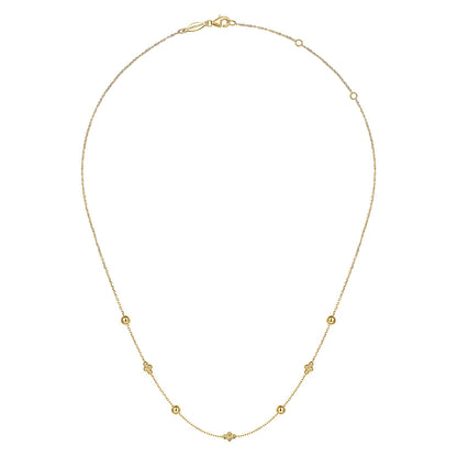 The 14K Yellow Gold Bujukan Bead Station Necklace by Gabriel & Co features a fine chain with small, evenly spaced round and floral-inspired beads, secured with a lobster clasp.
