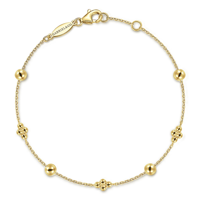 The 14K Yellow Gold Bujukan Beads Station Bracelet by Gabriel & Co features a fine chain with alternating polished round beads and floral-inspired clusters, secured with a lobster clasp and a subtle engraved tag.