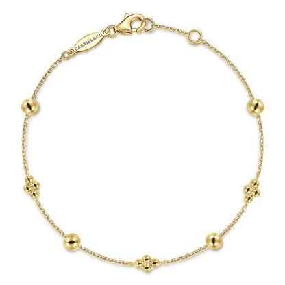 The 14K Yellow Gold Bujukan Beads Station Bracelet by Gabriel & Co features a fine chain with alternating polished round beads and floral-inspired clusters, secured with a lobster clasp and a subtle engraved tag.