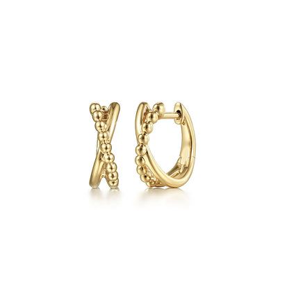 A pair of 14K Yellow Gold Bujukan Twisted Huggie Earrings by Gabriel & Co—one with a beaded design, the other smooth—are displayed elegantly on a white background.