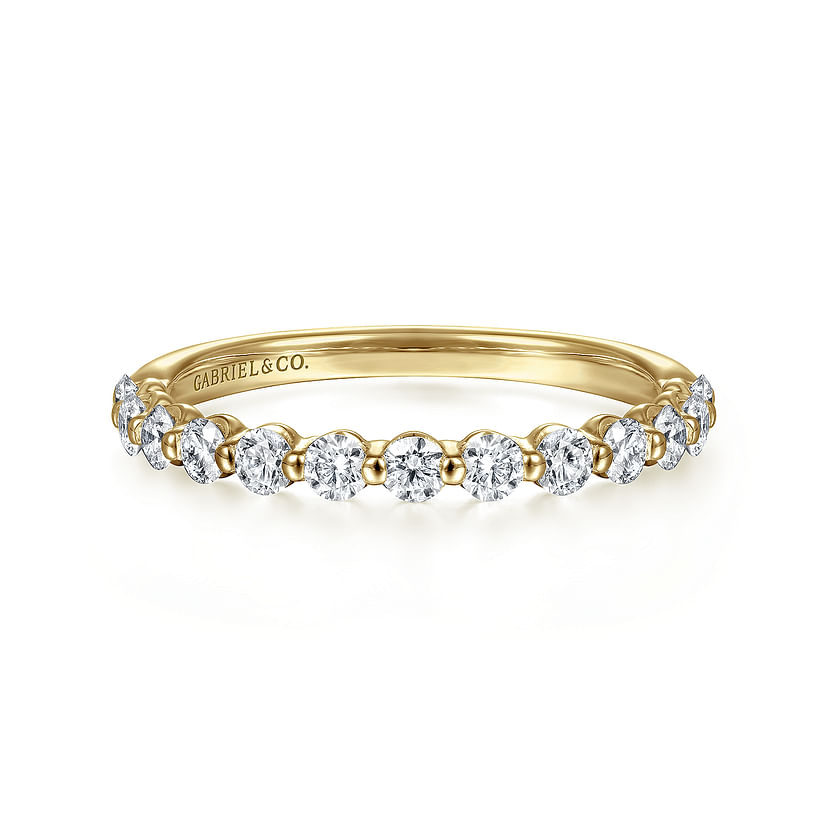 The 14K Yellow Gold Diamond Ladies Ring by Gabriel & Co features a row of natural diamonds on the top half and an engraved inside band, combining stackable luxury with an elegant, delicate design.