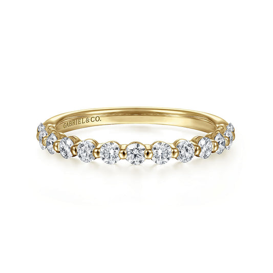 The 14K Yellow Gold Diamond Ladies Ring by Gabriel & Co features a row of natural diamonds on the top half and an engraved inside band, combining stackable luxury with an elegant, delicate design.