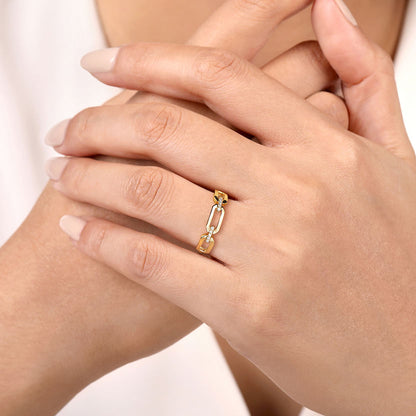 A close-up shows hands with neatly manicured nails wearing the Gabriel & Co 14K Yellow Gold Diamond Link Chain Ladies Ring, set against a softly blurred background.