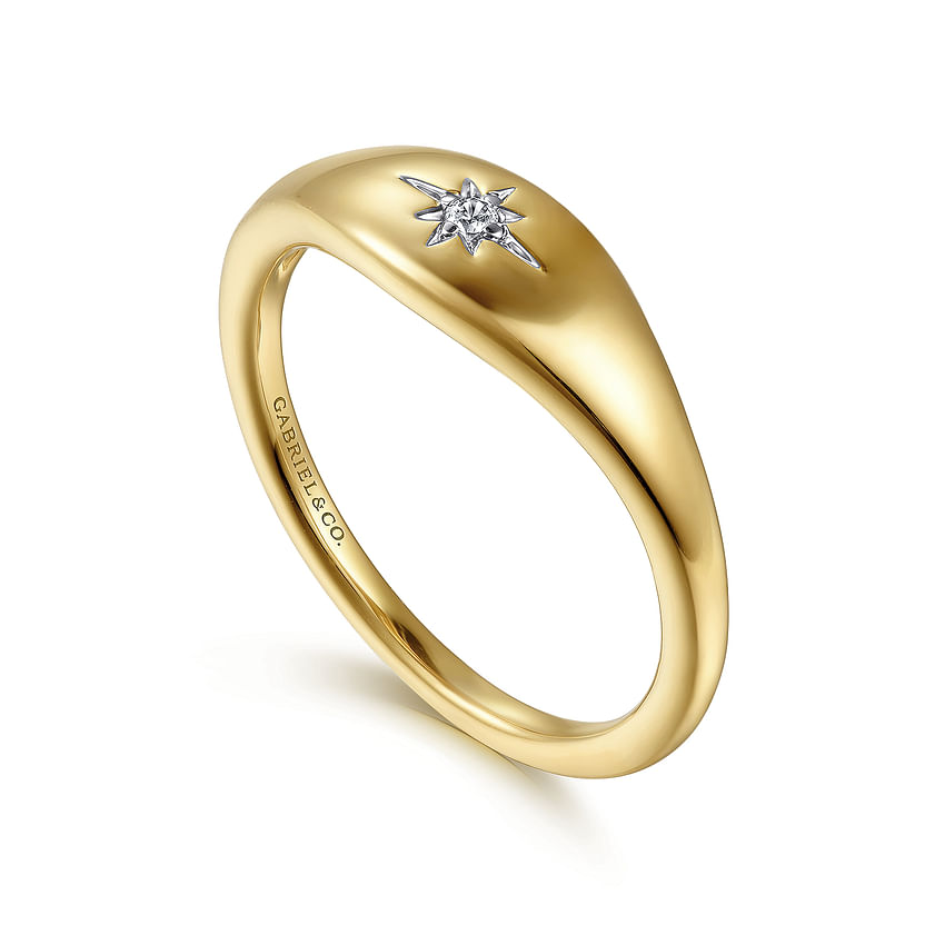 The 14K Yellow Gold Diamond Starburst Signet Ring by Gabriel & Co features a smooth, polished band with a small diamond in a starburst design—an elegant piece from Avonlea Jewelers.