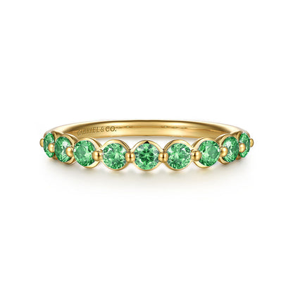 The 14K Yellow Gold Emerald Stackable Ring by Gabriel & Co showcases a row of round green emeralds along the band, with "GABRIEL&CO." engraved inside.